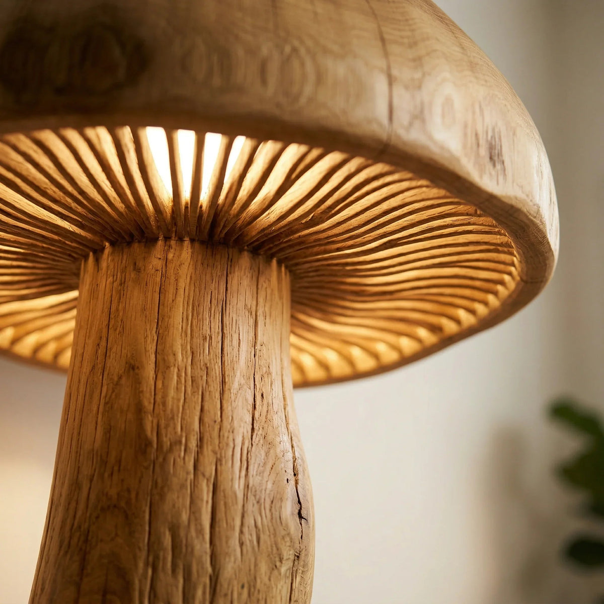 Nahaufnahme einer Riesen-Pilz-Stehlampe mit geschnitztem Holzstamm und leuchtendem Lamellendetail