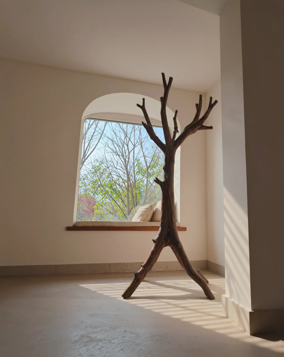 Nachhaltig gefertigtes Baum-Bücherregal aus Massivholz in einem sonnigen minimalistischen Raum an einer Fenstersitzbank.