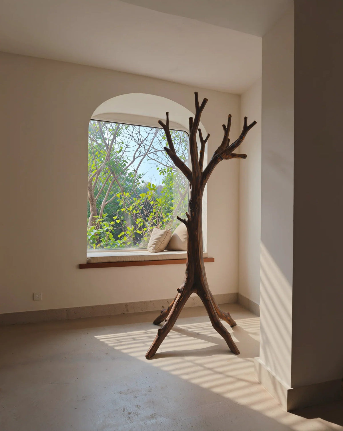Baum-Garderobe aus Massivholz in einem sonnigen minimalistischen Raum mit Fenstersitzbank und Grün draußen