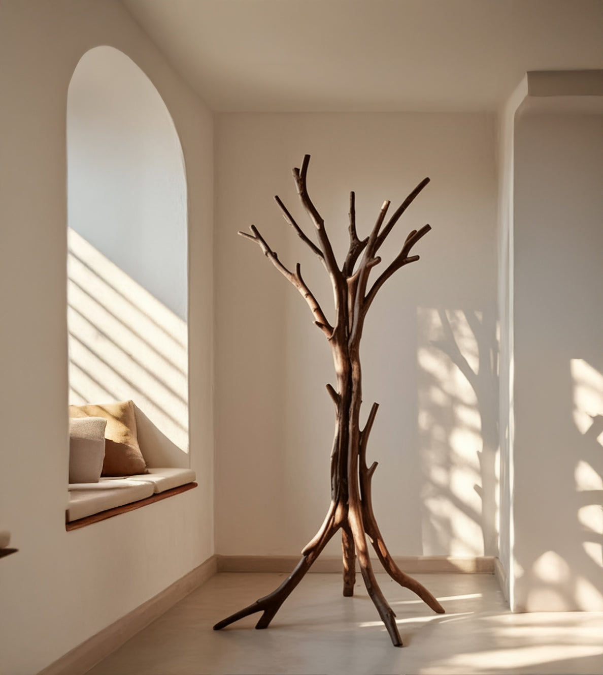 Minimalist interior with a wooden tree-shaped coat rack by a sunlit window seat with cushions