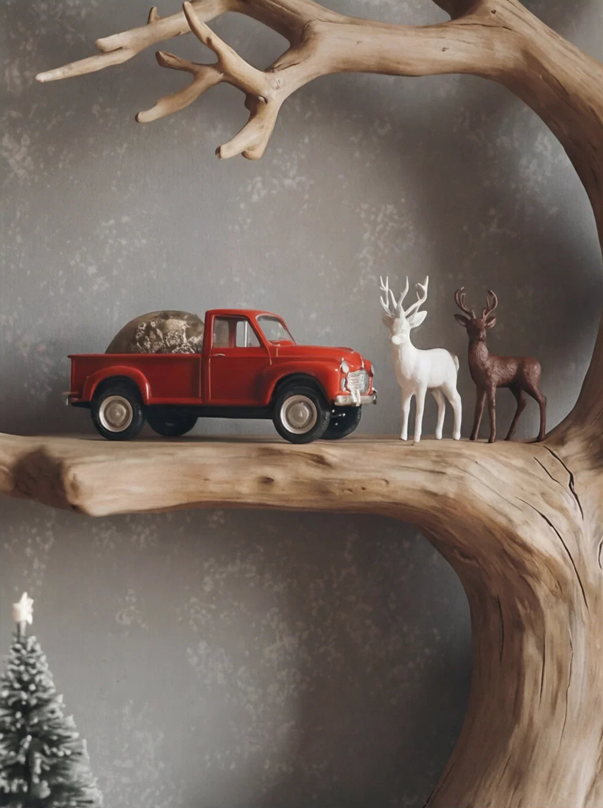 Rustikales Astregal in Baumform mit rotem Spielzeug-Lkw und dekorativen Hirschfiguren