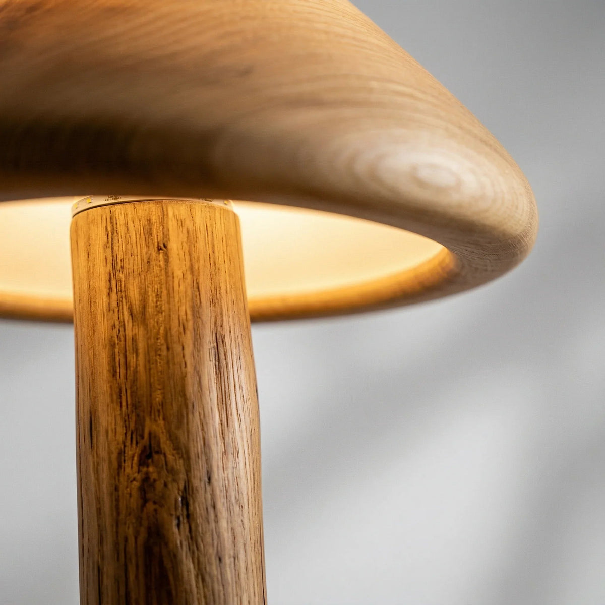 Nahaufnahme einer Holz-Stehlampe mit Kuppelschirm und warmem Downlight