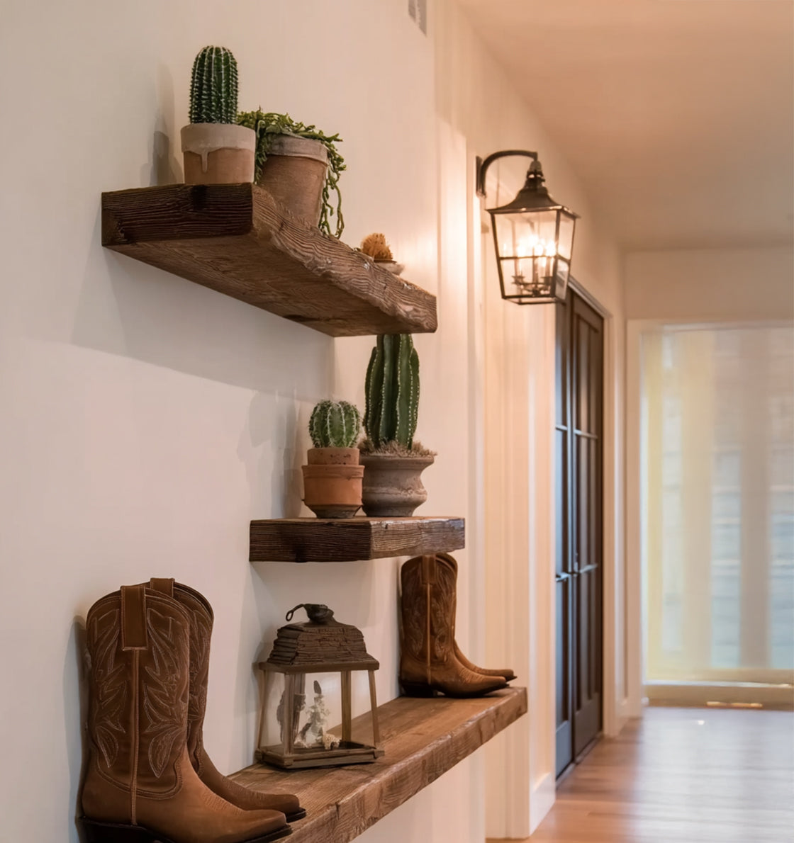 Rustic wooden shelves with potted cacti, decorative lantern, and brown cowboy boots in hallway