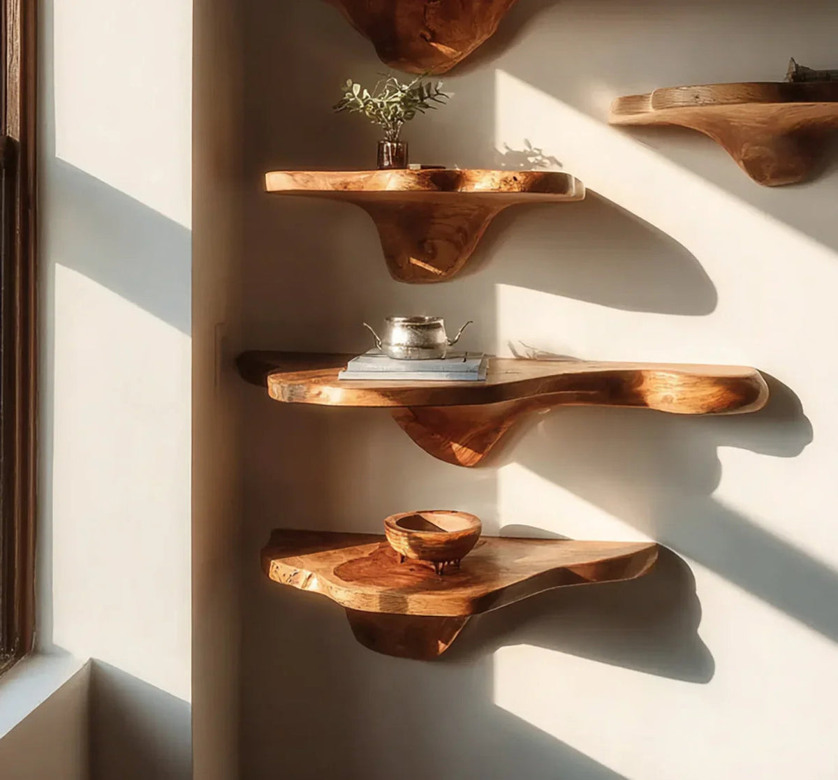 Schwebende Baumkanten-Regale aus Massivholz an einer Wand im natürlichen Sonnenlicht.