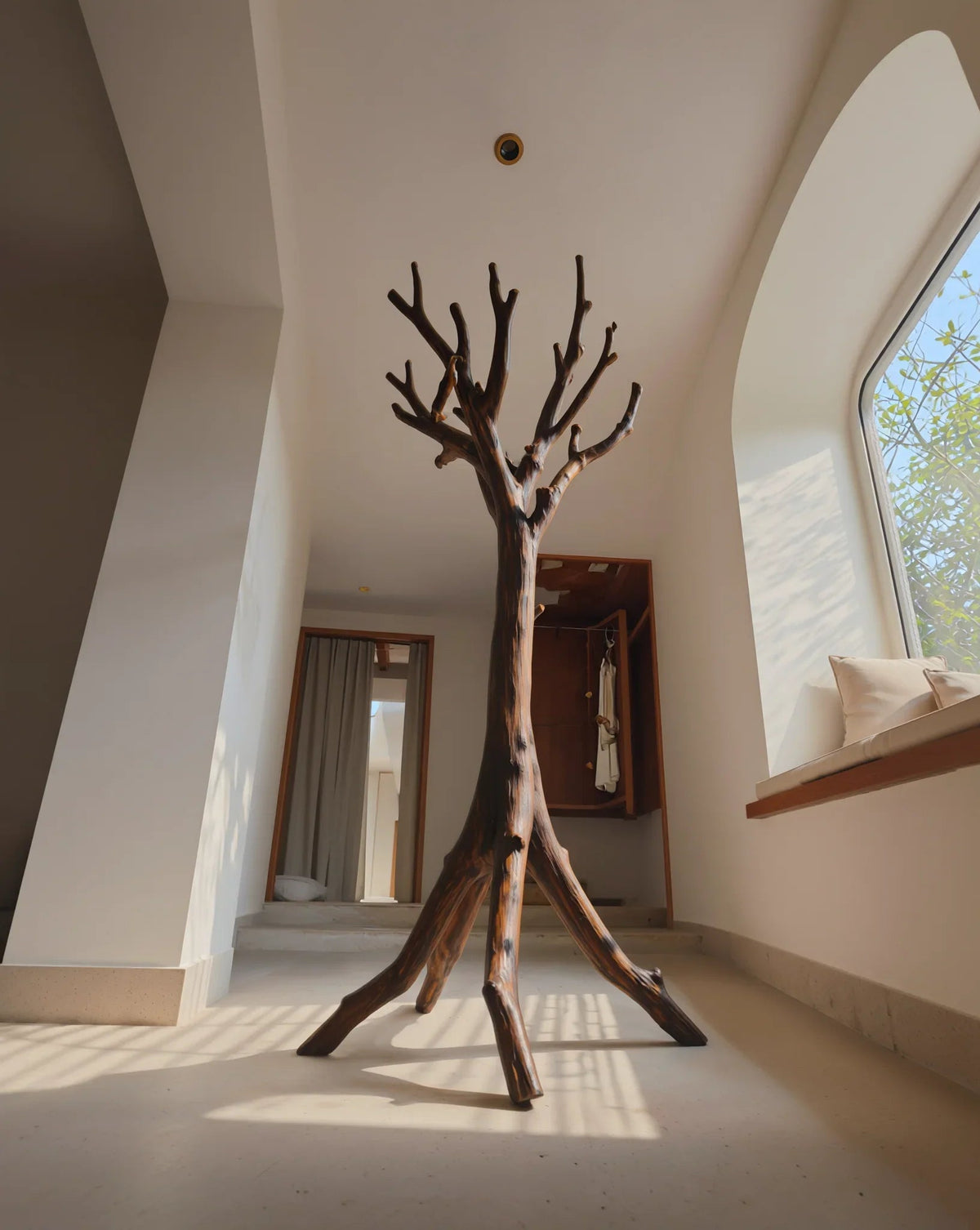 Baum-Bücherregal aus Massivholz mit natürlichen Ästen, moderner Flur, einfallendes Sonnenlicht